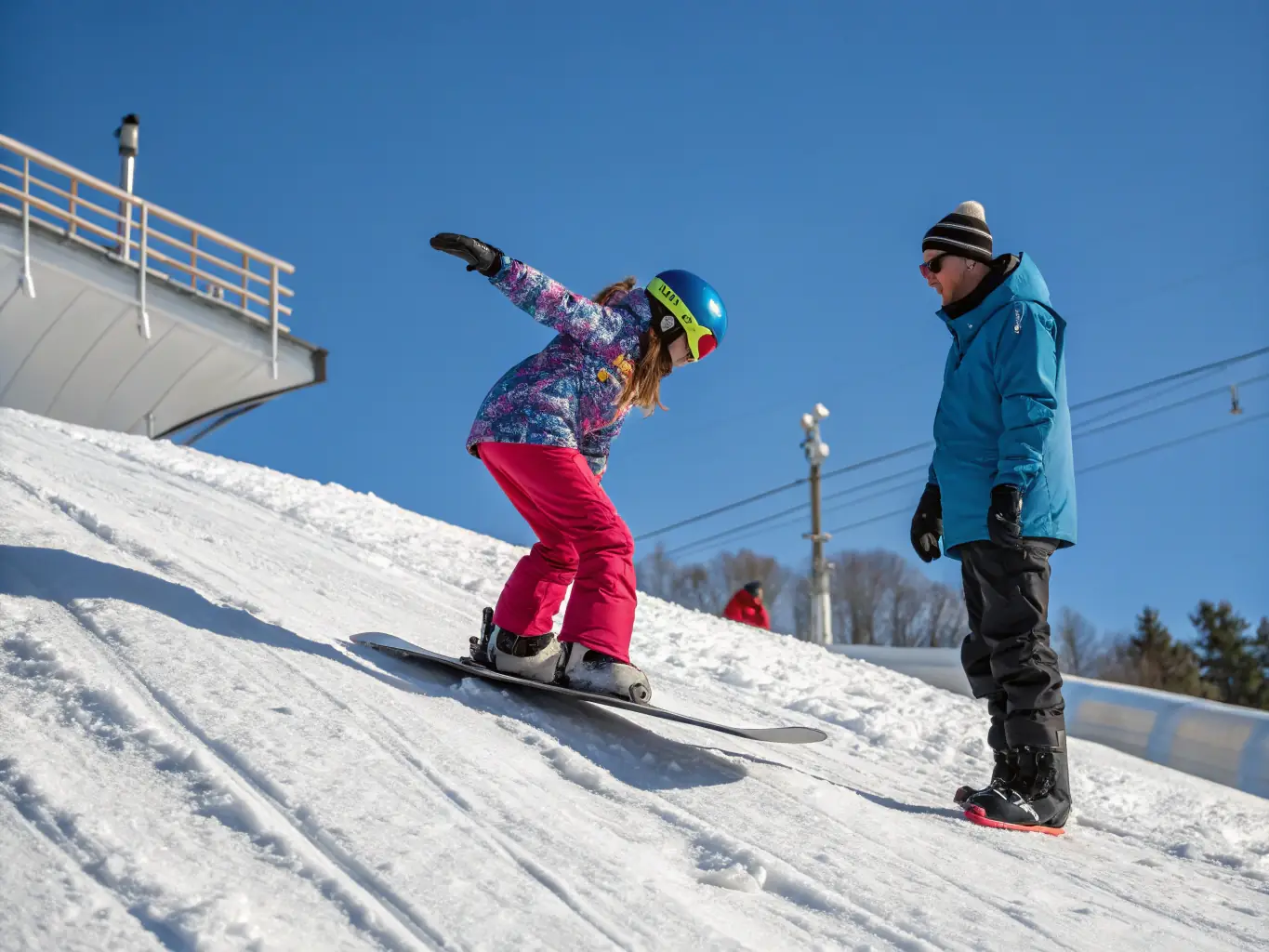 A snowboarder confidently executing a trick on the slope, with an instructor nearby providing guidance and encouragement at Warmwell Snowsports Centre.