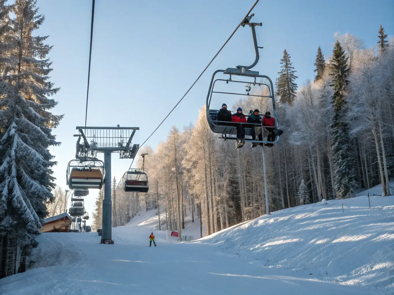 A modern ski lift carrying skiers up a snow-covered slope at Warmwell Snowsports Centre, showcasing the ease of access to the slopes.